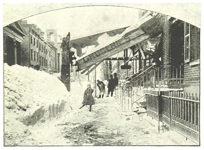 a young girl stands outside of a grocery store as her family shovels snow. the sign from the grocery store has been ripped down due to heavy ice and snowfall